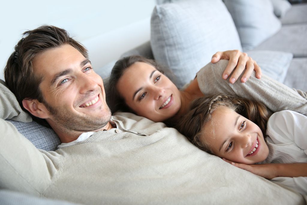 Parents with little girl laughing in couch